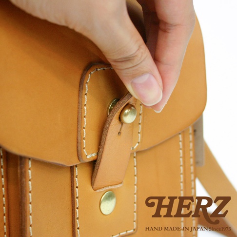 職人手作皮革休閒散步包，採用原色皮革製作，搭配黃銅釦飾與白色縫線，呈現簡約質感。