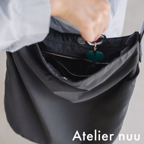 Atelier nuu ssent 肩背托特包，灰色，展示包包內部細節，可見一個綠色的愛心吊飾。