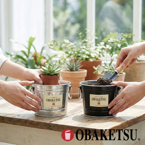 OBAKETSU 手工製多功能迷你桶，展示了將小盆栽放入銀色桶中，以及用小鏟子往黑色桶中填土的場景，背景為室內綠植。