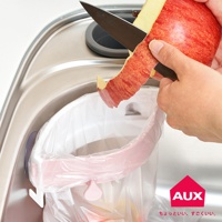 粉色開合式流理台廚餘架，可固定垃圾袋，方便削皮，上方為不銹鋼流理台。