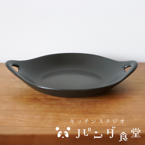 Kitchen Studio Panda食堂的黑色雙耳耐熱料理盤，置於木質桌面，背景為白色。