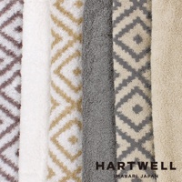 三款 CUOL 今治柔彈伸縮美肌枕套，包含菱形幾何圖案的棕色、米白色與灰色，以及素色的白色與淺米色，皆為絨毛材質。