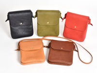 五款職人手作皮革橫式隨行袋，包含黑色、橄欖綠、紅色、淺棕色與深棕色。袋子以皮革製成，設計簡約，附有翻蓋和金屬鈕扣。