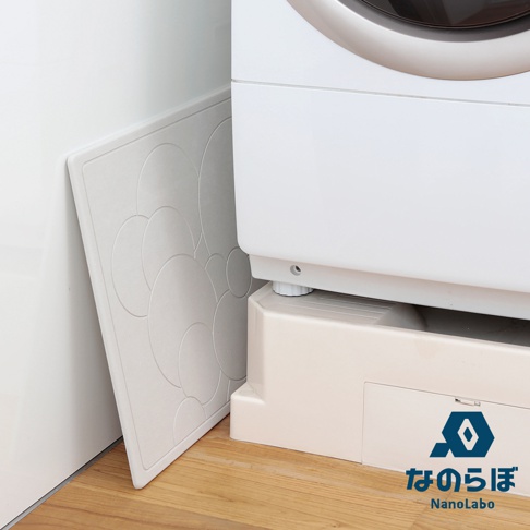 NANOLABO 品牌 logo 和日文名稱，旁邊是洗臉機的底部細節，左側為印有圓形花紋的淺色吸水墊，放置於木地板上。