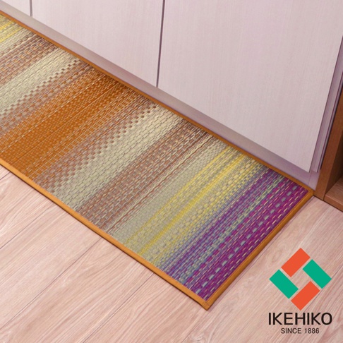 藺草編織的廚房地墊，尺寸為43x120cm，具有漸層色織紋，從橘色、米色、黃色到紫色，邊緣為橘色滾邊，鋪設在木地板上。