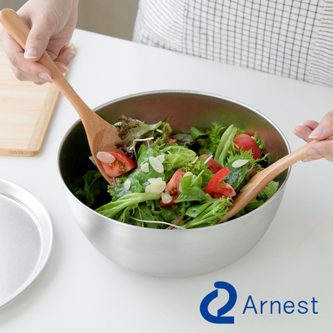 Arnest 逸品物創防刮不鏽鋼調理碗，使用木製沙拉夾混合碗中的沙拉，碗內有生菜、番茄和杏仁片。