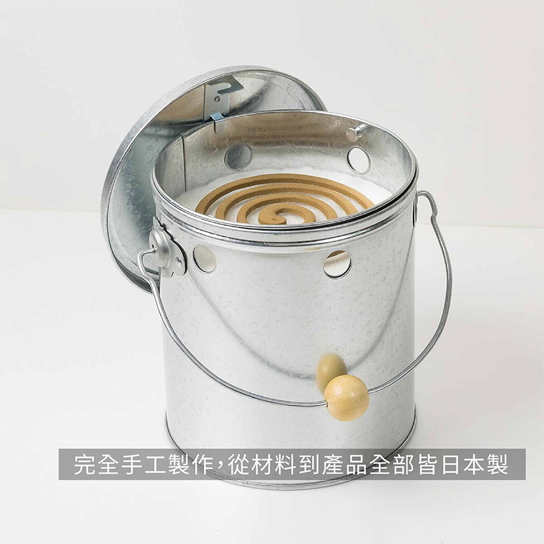 OBAKETSU 手工製蚊香桶，由鍍鋅鋼板製成，附有木製提把，桶蓋已打開，露出內部的蚊香。