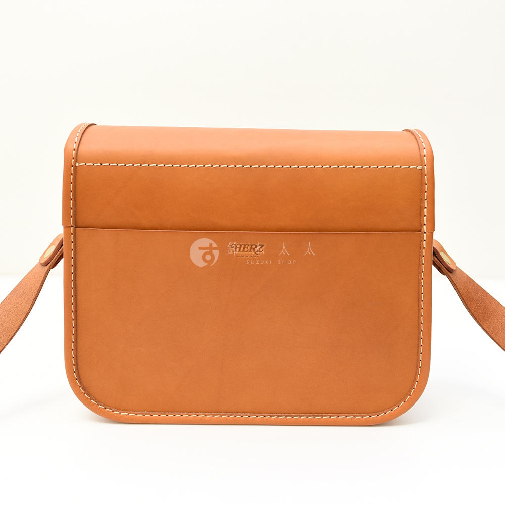 日本HERZ職人手作皮革經典雙扣郵差包，展示品牌標誌和日文SUZUKI SHOP字樣，材質為棕色皮革。