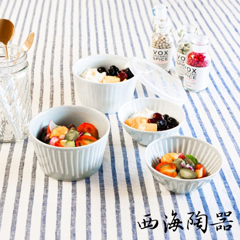 波佐見燒 FUWARI 四件式碗碟，淺灰色調，帶有垂直條紋設計。其中三個碗盛有水果沙拉和優格，一個碗內有蔬菜沙拉。背景有玻璃罐和調味料瓶。