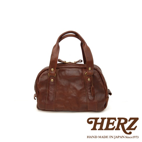 職人手作咖啡色皮革迷你波士頓包，呈現水洗加工的自然紋理，包身圓潤，配有雙提把及金屬配件。