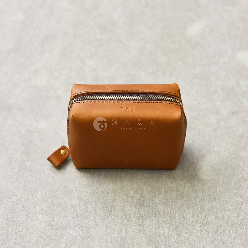 一個方形的棕色皮革收納包，上有拉鍊和品牌標誌，側面有一個小皮革拉環。