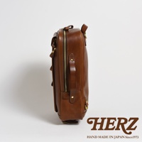 棕色皮革製成的兩用後背包，側面展示，配有金色拉鍊和扣環，以及提把。