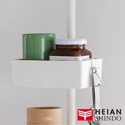 白色長方形收納盒，內有綠色杯子和一瓶琥珀色液體。收納盒側面掛有銀色金屬量匙組。