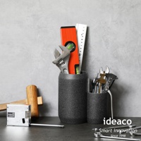 兩個砂岩材質的收納筒，一個較高，一個較低，皆裝有各種工具，包括水平尺、扳手、捲尺和卡尺。