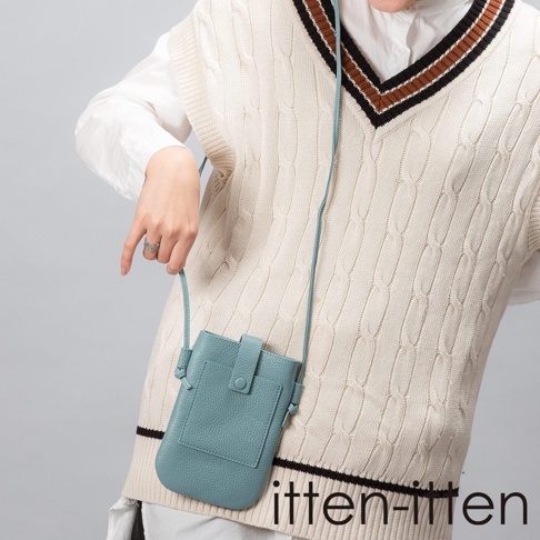 itten-itten 品牌 LOGO，配戴白色內搭和米白色菱格紋針織背心的模特兒，手拿著一個淺藍色皮革手機包。