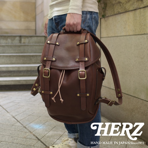 職人手作皮革經典雙扣後背包 R-152，深棕色皮革，配有黃銅色雙扣和抽繩。