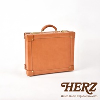 職人手作皮革英倫風便攜手提行李箱，以棕褐色皮革製成，配有金色金屬扣環和頂部提把。箱體邊緣有縫線裝飾，底部和四角有加固皮革。