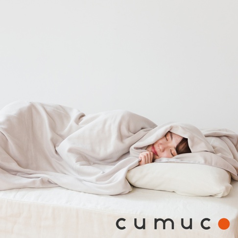 CUMUCO 四層紗輕暖舒柔四季毯，淺灰色，展示一位女性舒適地臥於床上，蓋著柔軟的毯子，毯子呈現自然的垂墜感。