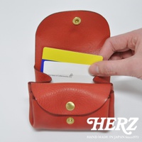 紅色皮革三層收納零錢包，內有黃色與白色卡片，包款有金色釦子，材質為皮革。