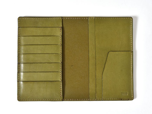 橄欖綠皮革多用途長夾，展開狀態。左側有六個直式卡槽，右側有兩個隔層，其中一個為斜口設計。整體皮革表面光滑，帶有縫線細節。