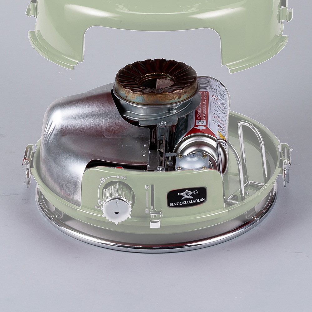 淺綠色卡式瓦斯暖爐，內部有金屬反射罩、燃燒器和瓦斯罐，爐體邊緣為銀色金屬。