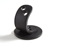 黑色皮革製成、可容納兩支筆的筆架，底部為圓形，上方彎曲的皮革有兩個筆孔，邊緣縫線清晰。