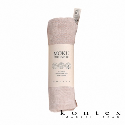 MOKU ORGANIC 有機棉食材染料長毛巾，採用柔軟的有機棉材質，呈現柔和的淺粉色調。毛巾捲起後，外層包覆著印有品牌標誌與產品資訊的紙帶。
