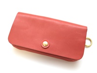 桃紅色皮革長夾，設有金色金屬按扣和側邊金色圓環，展現多層次結構。