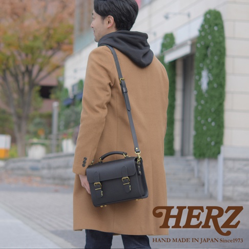 職人手作黑色皮革極簡風兩用迷你單肩包，配有可調節的肩帶和金色金屬釦，由真實皮革製成。