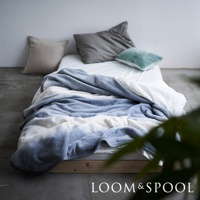 Flood of Light 抗菌短絨舒柔單人毯，採用柔軟的短絨材質，呈現藍白色漸層設計，鋪陳於床鋪上，旁邊擺放數個不同顏色與質感的抱枕。