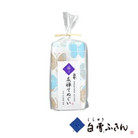 友禪染廚房兩用長拭巾，以淺藍色與米白色為底，印有淺藍色與米色的蝴蝶圖案，材質為棉，包裝為透明塑膠袋，以麻繩綑綁。