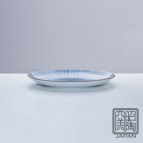 藍染千段十草紋樣的白色陶瓷圓盤，邊緣飾有細緻的棕色線條。