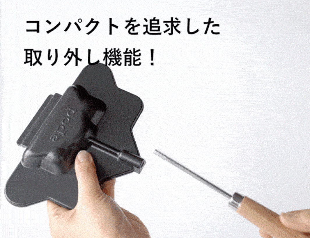 一個黑色的熱壓三明治烤夾，形狀像星星，帶有一個木柄金屬桿，用來固定或拆卸烤夾。