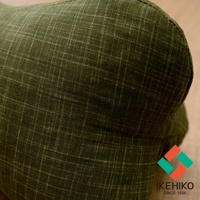 橄欖綠多功能紓壓骨頭枕，表面為細緻格紋織紋，材質觸感樸實。