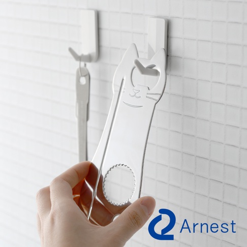 銀色金屬貓造型開罐器，貓臉設計有眼睛、鼻子和鬍鬚線條，上方有開瓶器開口，下方有圓形鋸齒狀開口，由手持於白色磁磚牆壁背景前。