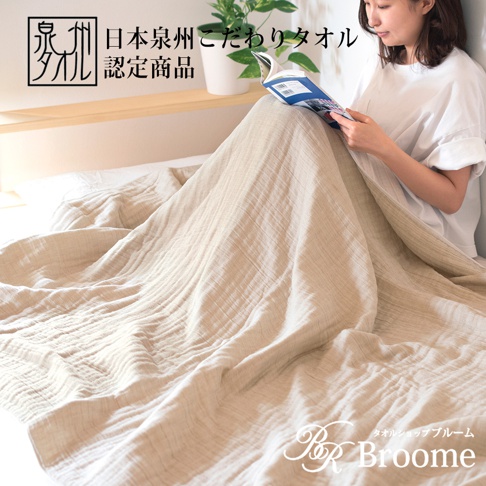 泉州SASARA四層紗毛巾毯，米白色，輕盈柔軟，呈現細膩的織紋，蓋在身上，一位女性坐在床上閱讀。