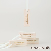 數塊淺色木質檜木條，上面印有「Natural Hinoki Block TONARINO」字樣，其中一塊檜木條懸掛在白色緞帶上，另兩塊堆疊擺放，其中一塊有白色緞帶穿過。