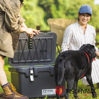 HUGEL 真空隔熱冰桶40L VITC-40，黑色塑膠材質，頂蓋內側有彈性繩網，可固定物品。冰桶旁有一名男子正在拿取飲料，一名女子坐在椅子上，一隻黑狗在旁。