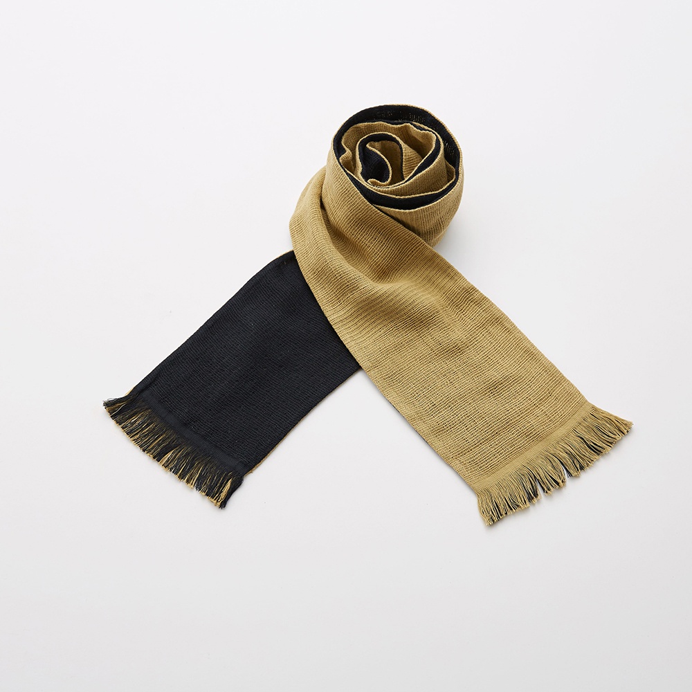 今治匹馬棉雙色圍巾，一端為黑色，另一端為卡其色，兩端皆有流蘇裝飾。