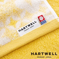 黃色今治和風傳統紋樣言織浴巾，標籤印有「HARTWELL IMABARI JAPAN」字樣，材質為柔軟的棉質毛巾布。