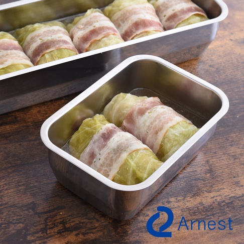 不鏽鋼烤盤中擺放著用培根包裹的燉菜，品牌Arnest的標誌印在圖片右下角。