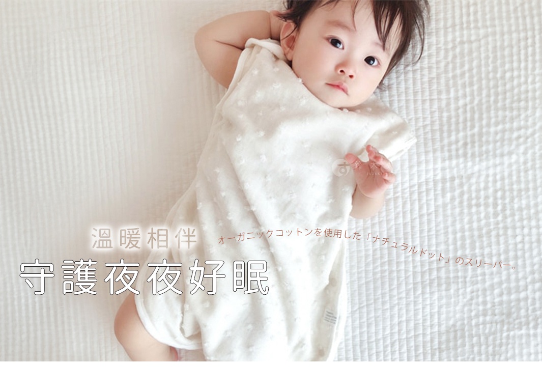 一名女嬰躺在米白色水玉點點無撚紗質的透氣防踢被心中，背景是米白色的格子紋床單。