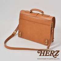 咖啡色皮革三用單扣商務後背包，附有可調節長度的皮革肩帶及提把，包身側邊有金屬 D 型環。