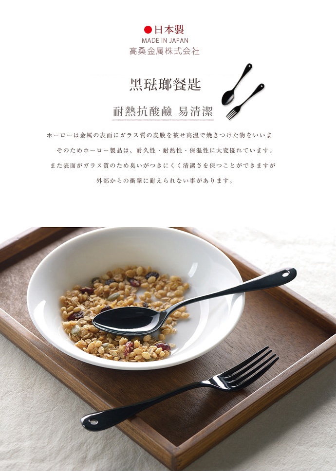 日製黑琺瑯餐匙，一湯匙一叉，光滑黑亮琺瑯材質，湯匙置於裝有麥片穀物的白色碗中，叉子則在碗旁。