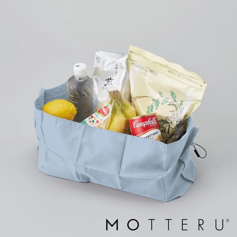 淺藍色摺疊束口袋，裝有檸檬、瓶裝飲料、香蕉、罐頭湯品及兩包食品。材質輕薄，束口處有細繩。
