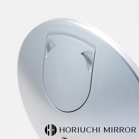 銀色霧面金屬材質的圓形化妝鏡，鏡面邊緣有貓耳造型設計，下方印有 HORIUCHI MIRROR 品牌標誌。