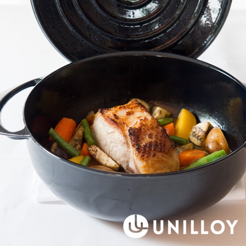 黑色琺瑯鑄鐵鍋內盛有烤肉塊及胡蘿蔔、四季豆、馬鈴薯等燉菜。