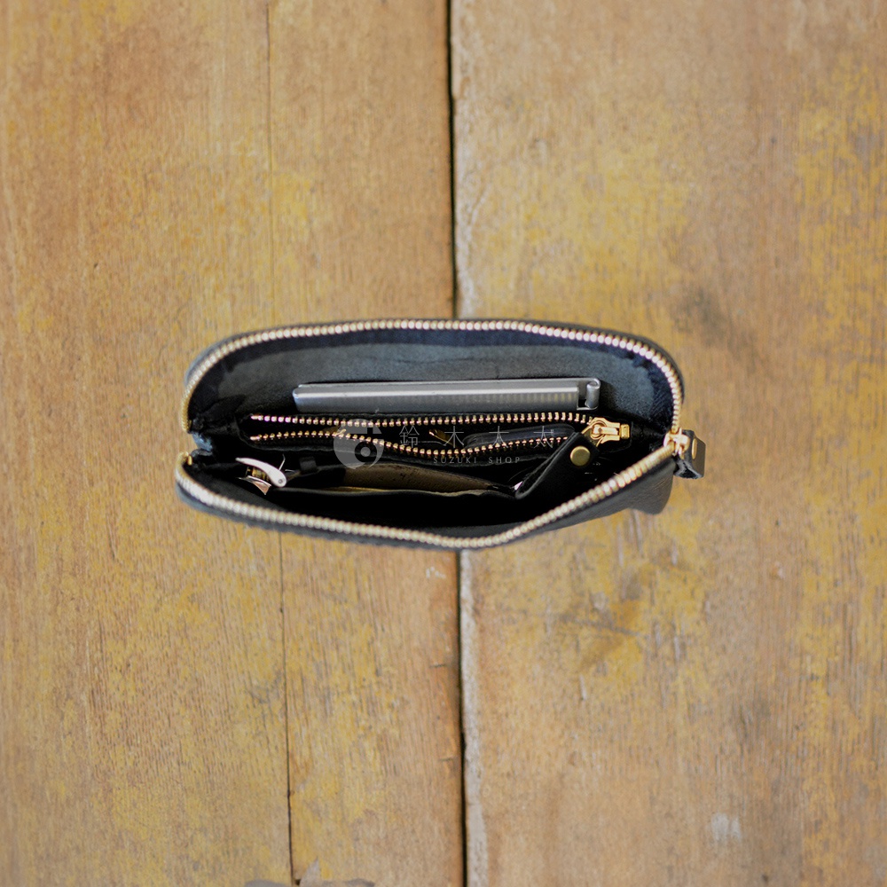 黑色皮革手作Organ雙拉鍊收納袋，內部空間整齊，可見手機、卡片、零錢等物品，拉鍊為金色。