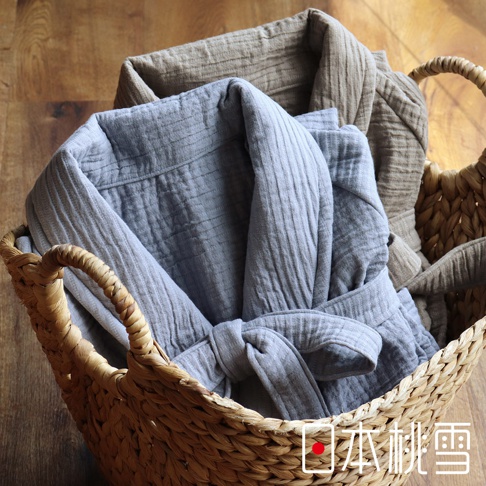 籃子裡有兩件雙面紗布浴袍，一件是灰色，一件是卡其色。兩件浴袍都採用立體織紋設計，並繫有腰帶。