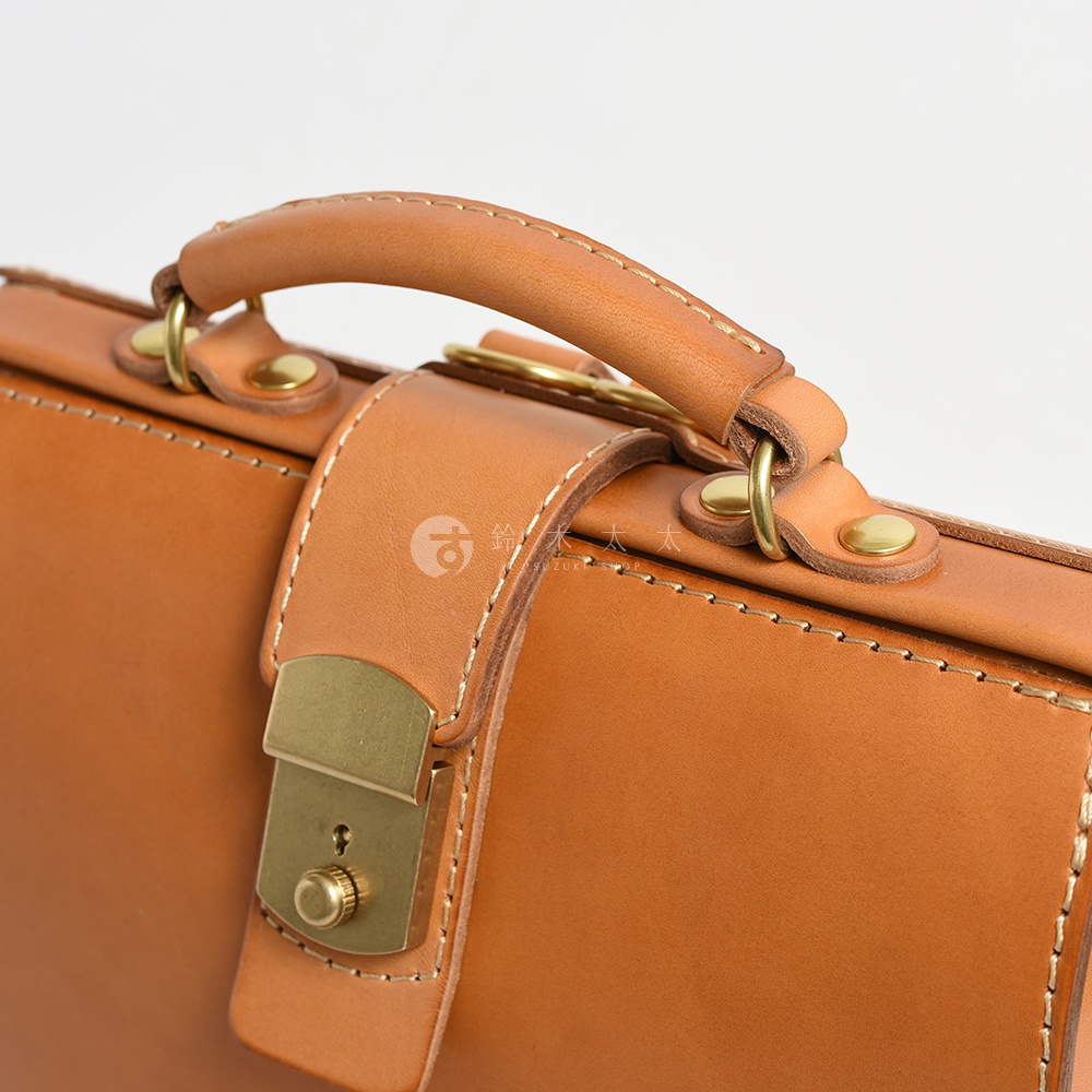 職人手作皮革杜勒斯商務後背包，特寫展示焦糖棕色皮革材質、精緻縫線、黃銅色鎖扣及提把，展現復古與高品質的細節。